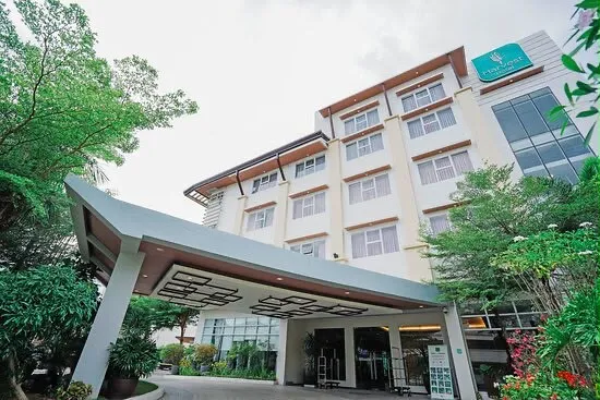 Multi-storey hotel framed by tropical trees in Cabanatuan City