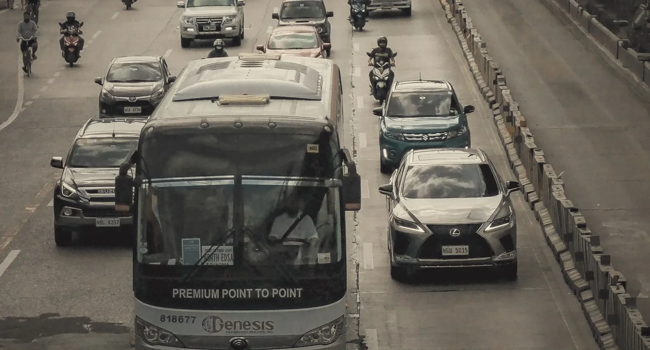 Provincial bus among cars on a Metro Manila highway