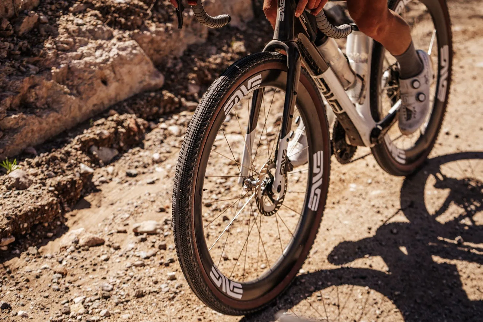 Gravel bike with ENVE wheels and tan-wall tires kicking up dust on a dirt road
